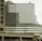 A modern multi-story office building with a white and glass facade, including a domed section at the top. Multiple flags are visible on the lower part of the building. In the foreground, there is a concrete parking structure with multiple levels, including visible vehicles.